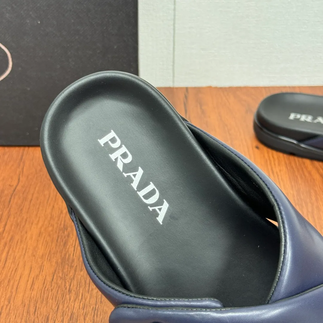 Batch 580 Prada/Prada's new men's leather cross slippers. Velcro closure can finely adjust the size. Calf leather light luxury slippers. Thick soft calf leather wraps the upper. Fat but soft rubber lazy style, soft and comfortable, excellent foot feel. Genuine leather bottom layer, cross style, with a Velcro closure buckle, easy to adjust the appropriate size, and a perfect fit for the wearing experience. The enamel gold triangle logo highlights the brand's classic features. Lightweight rubber thin sole, high foot comfort! Complete package! Size: 39-40-41-42-43-44-45 Leather shoe size Item number: 2X7132 Blue